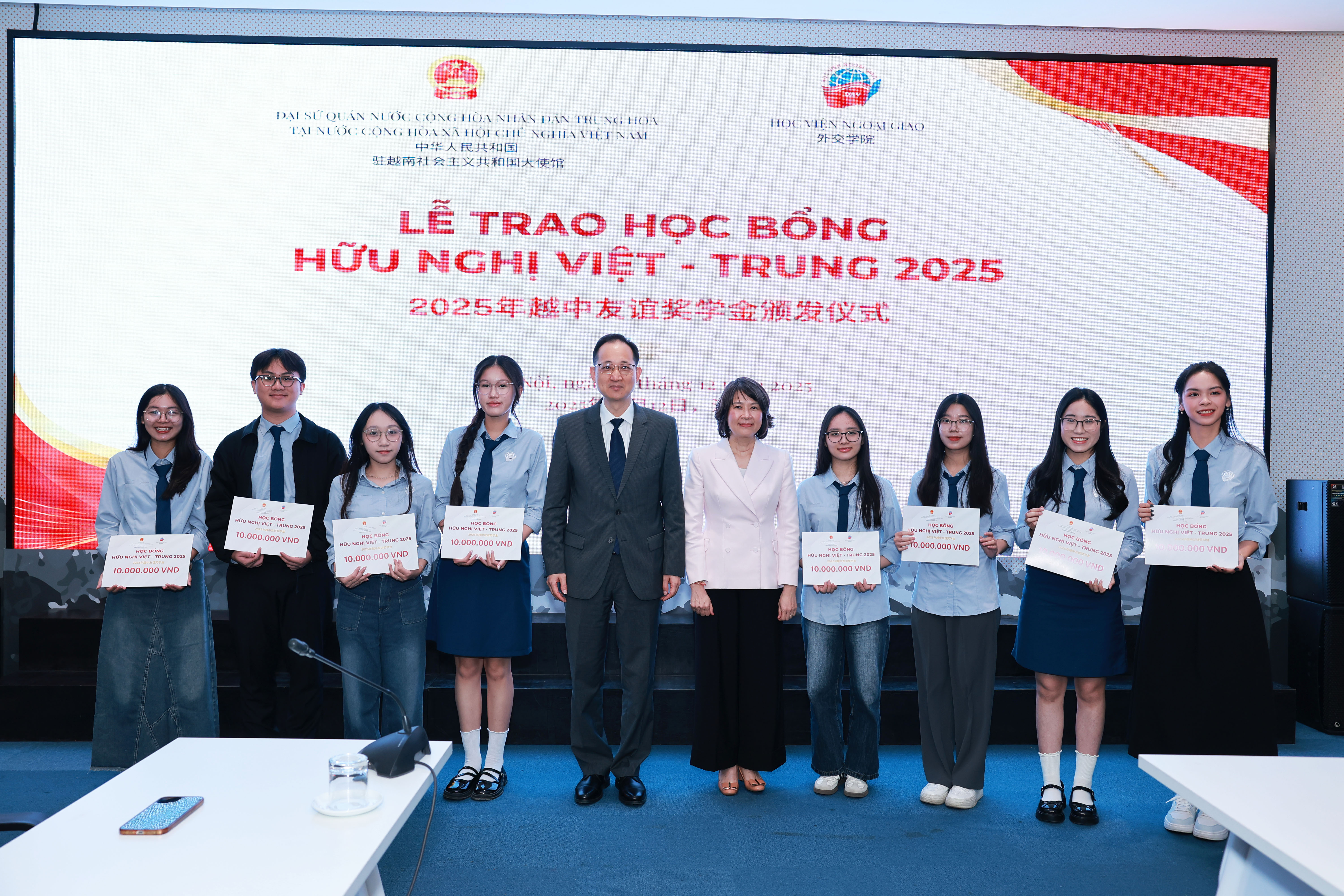 Minister Counsellor Wang Qun and Dr. Nguyen Thi Thin present scholarships to outstanding students